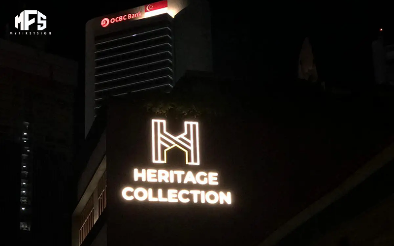 Illuminated Heritage Collection shopfront sign in Singapore at night.
