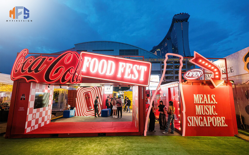 Vibrant red neon signage for a Coca-Cola event at an outdoor festival in Singapore