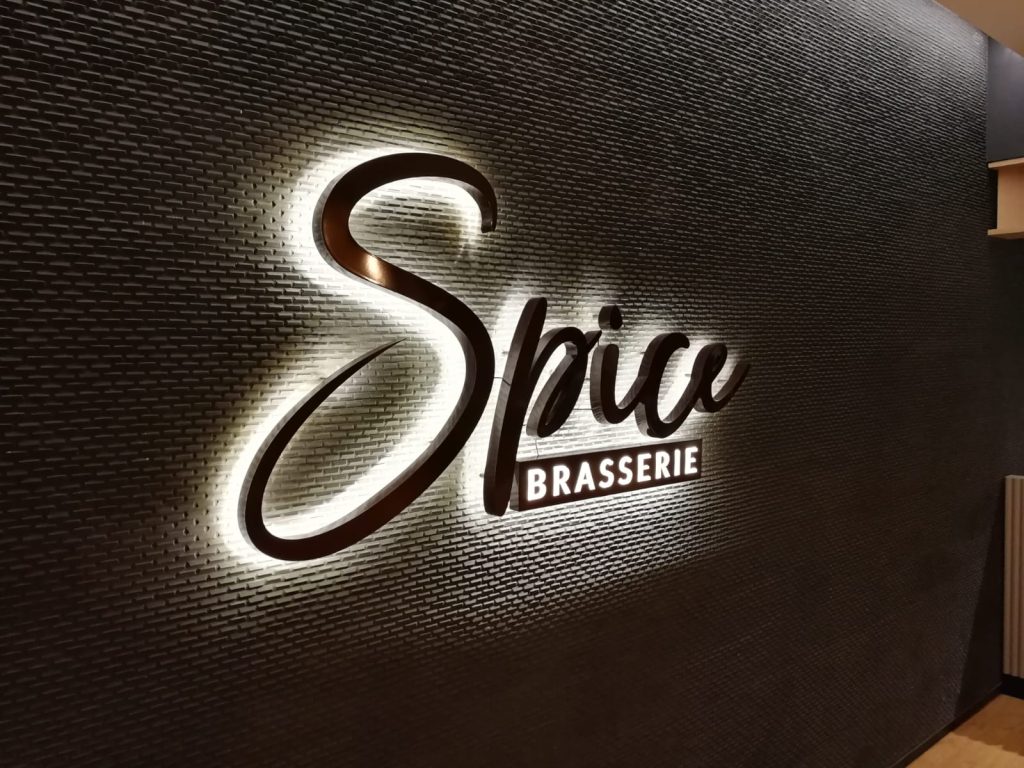 A backlit company logo sign mounted on a wall